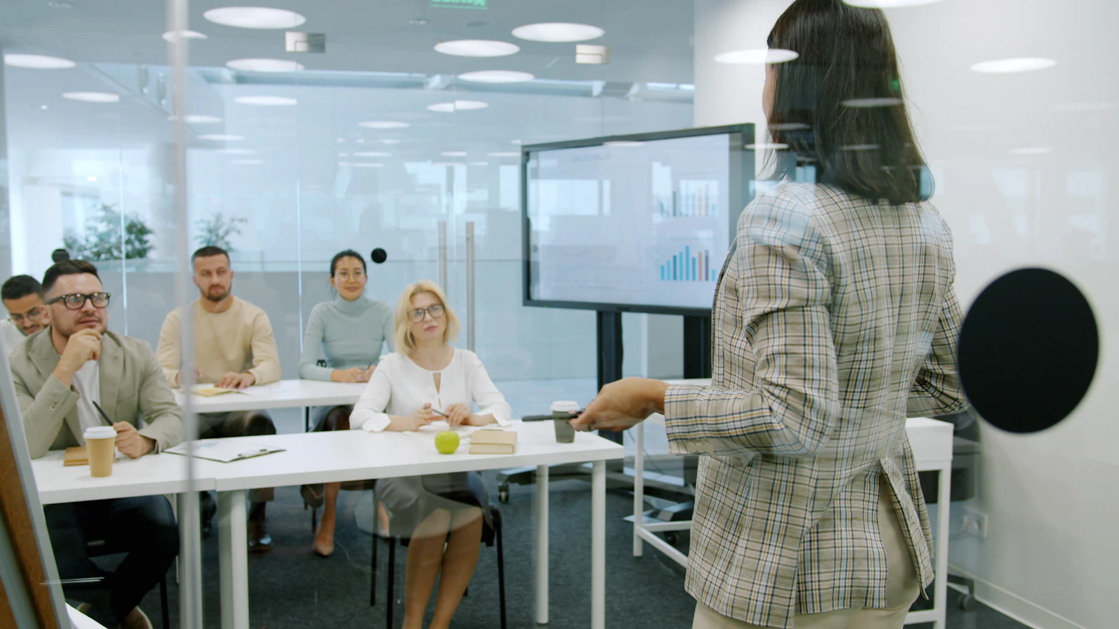 A woman leading a presentation for colleagues in a bright office