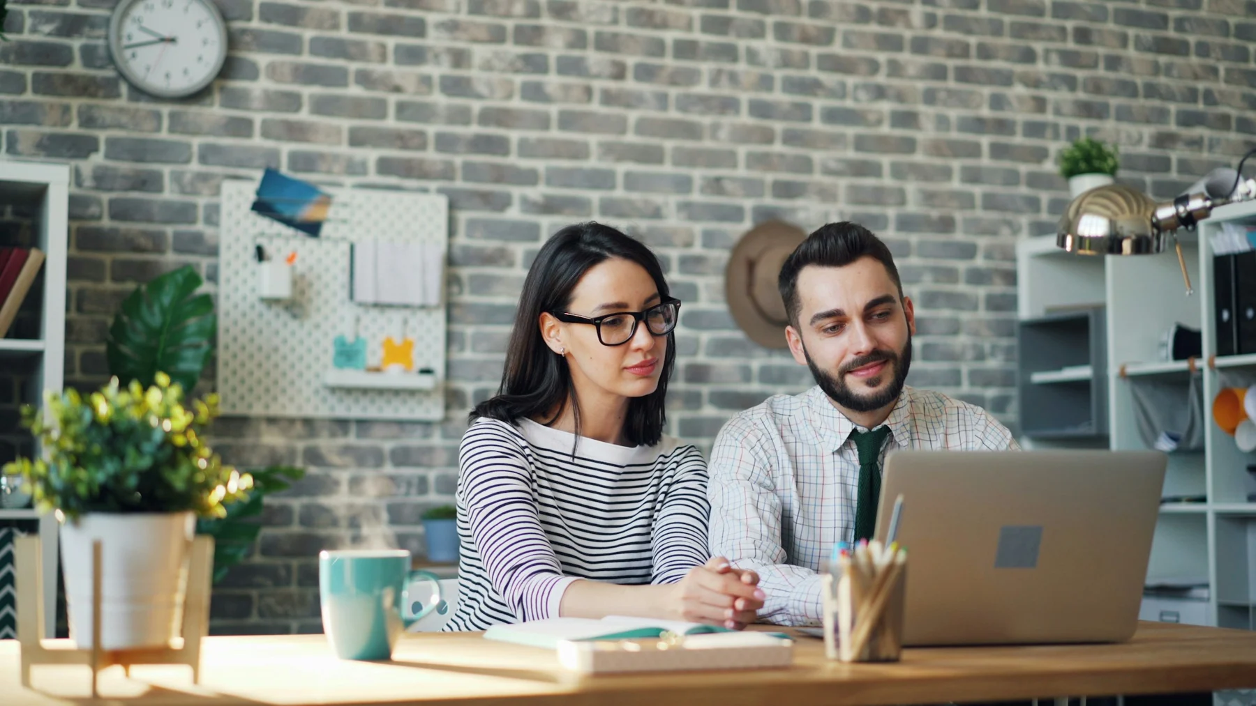 Two professionals working together on a laptop
